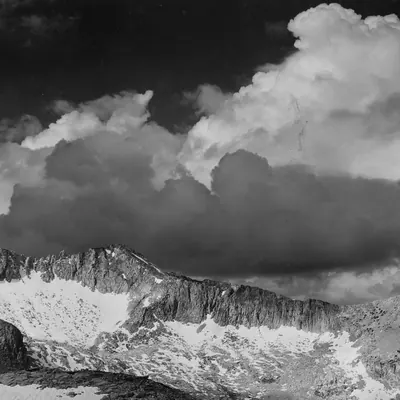 Riferimento scelto: nuvole dense sopra una cresta rocciosa, in bianco e nero